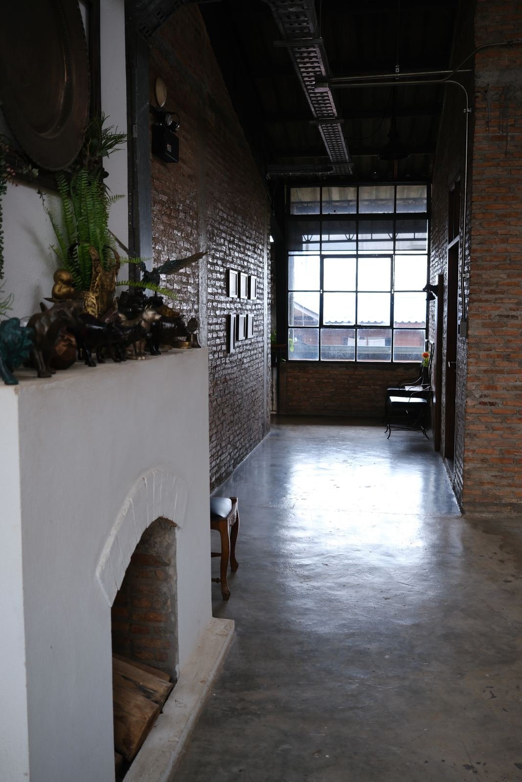 Concrete hallway leading to a steel-framed window